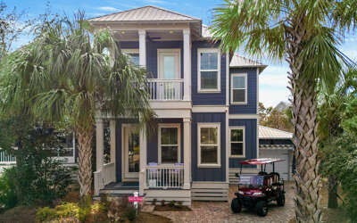 Charming coastal retreat with tropical palm trees and convenient golf cart parking for easy beach town exploration.