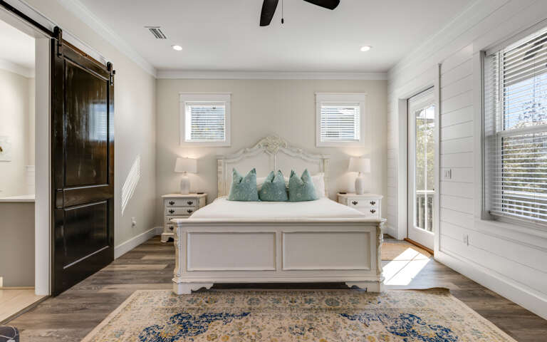 Drift into peaceful dreams in your elegant bedroom sanctuary, featuring coastal-inspired touches and charming barn door details.