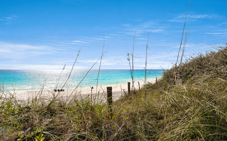 Pristine beach with turquoise waters and natural dunes creates a peaceful coastal setting near the property.