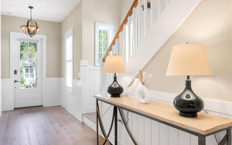 Interior Entryway With Table, Lamps, And Staircase