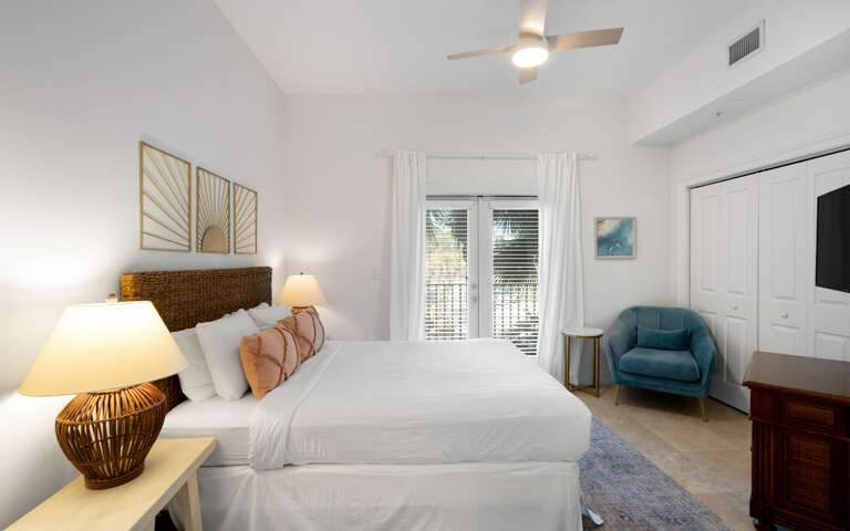 Unwind in your serene bedroom featuring a plush king bed, cozy reading chair, and stylish coastal decor that creates the perfect retreat.