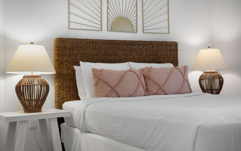 Sink into crisp white linens and soft textures in your beautifully appointed bedroom, where warm lighting creates the perfect ambiance for restful nights.