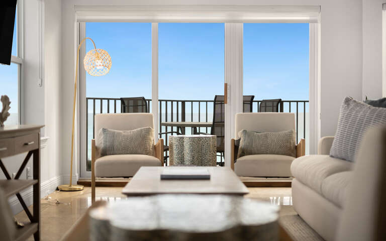 Unwind in your bright living room where soft seating and golden lighting create the perfect retreat after exploring.