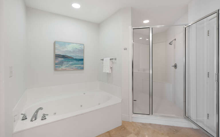 Unwind in your spa-like bathroom featuring a luxurious jetted tub and spacious glass shower, perfect for relaxing after your adventures.