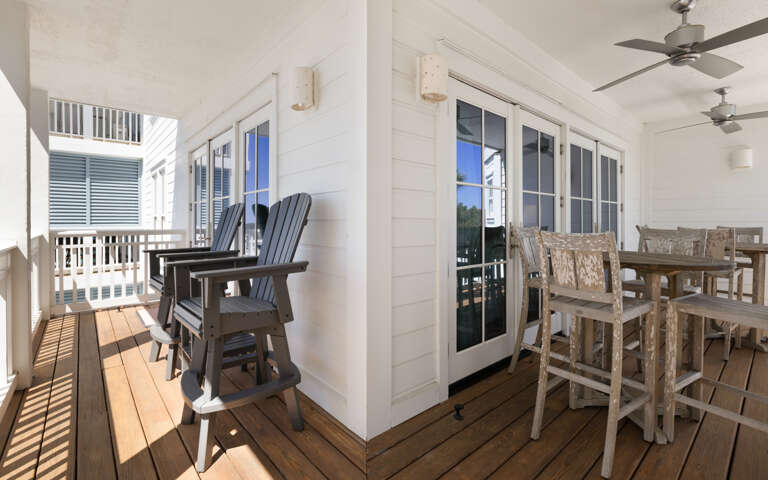 Your covered balcony offers the perfect spot to unwind with morning coffee or evening drinks, featuring comfortable seating and dining space.