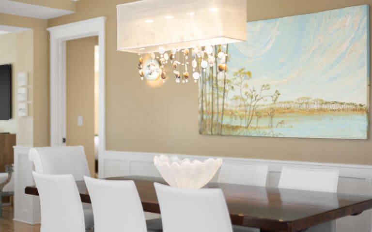Gather around your elegant dining table where thoughtful touches and beautiful artwork create the perfect atmosphere for memorable meals together.