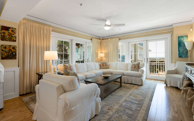 Sink into plush white sofas in your bright living room, where warm lighting and ocean breezes create the perfect retreat.