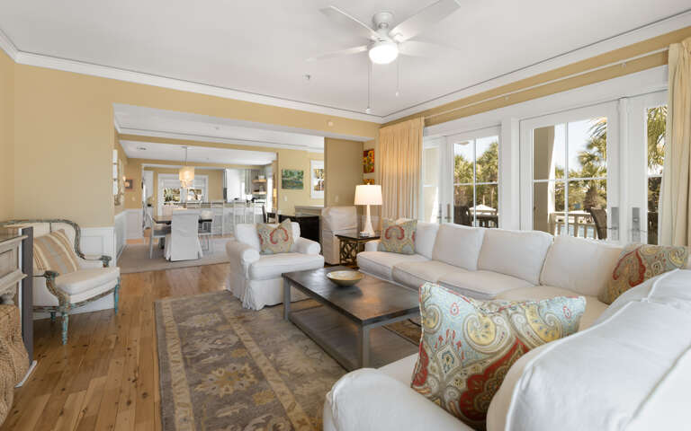 Unwind in your spacious living room with plush seating and tropical views through French doors leading to your private balcony.