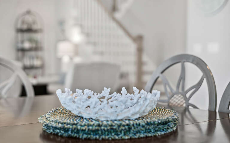 Admire elegant touches like this delicate coral bowl centerpiece while you dine at your stylish glass table.