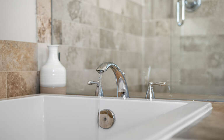 Slip into your elegant marble-tiled bathroom and unwind in the deep soaking tub with polished chrome fixtures.