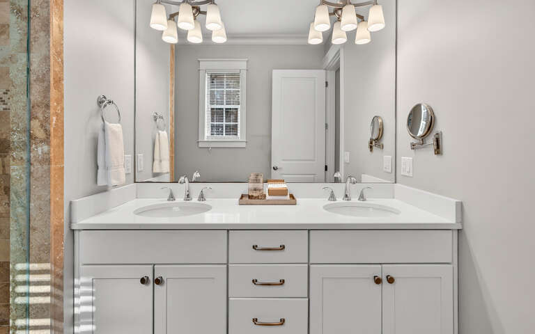Step into your private spa-like bathroom with dual vanities, elegant lighting, and fresh towels awaiting your arrival.
