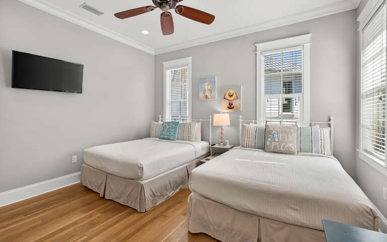 Your peaceful queen bedroom offers comfortable beds, ceiling fan, and natural light for a restful stay.