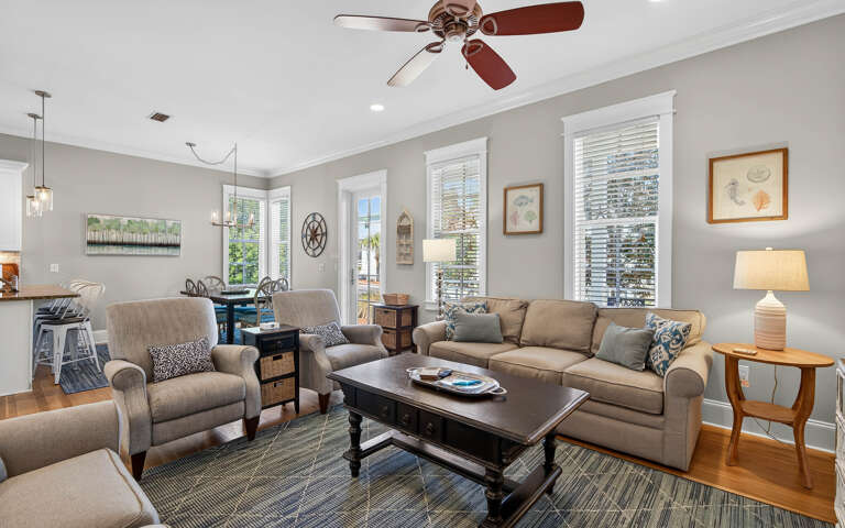 Relax in this beautifully appointed living room with comfortable seating, thoughtful decor, and plenty of natural light streaming through plantation shutters.