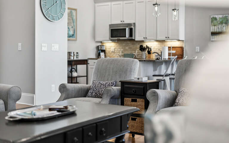 Sink into these plush armchairs and feel instantly at home in your thoughtfully designed open-concept space, where the modern kitchen awaits your culinary adventures.