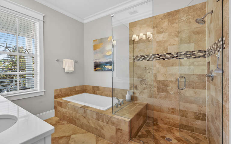 Unwind in your luxurious master bathroom featuring a spacious glass shower and elegant soaking tub, perfect for relaxing after your adventures.