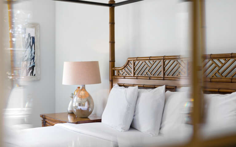 Interior Of A Vacation Rental Bedroom With Bamboo Headboard And Lamp