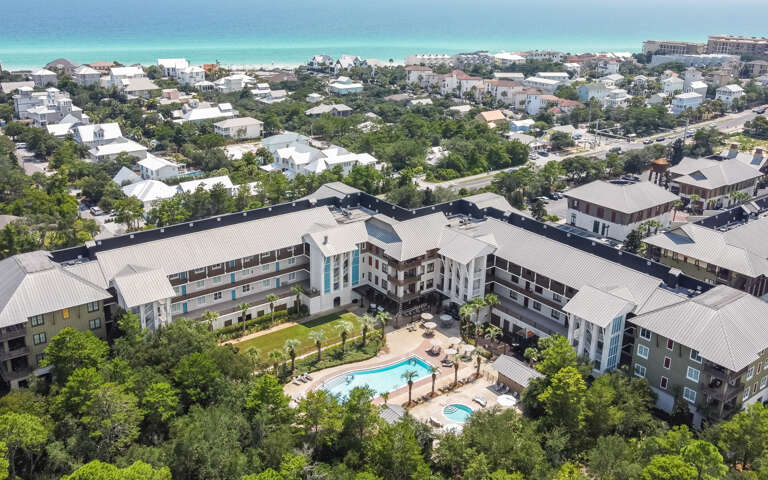 Aerial View Of A Residential Complex With Pool Near Beach