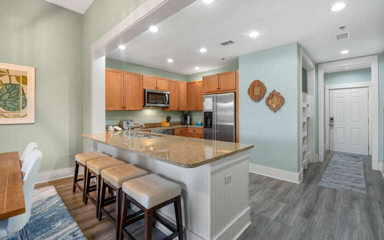 Your open-concept kitchen flows seamlessly into the living space, featuring granite countertops, stainless appliances, and a breakfast bar perfect for morning coffee.
