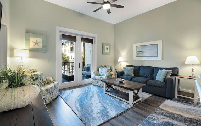 Sink into comfortable coastal-inspired furnishings while ocean breezes flow through your private balcony doors in this serene living space.