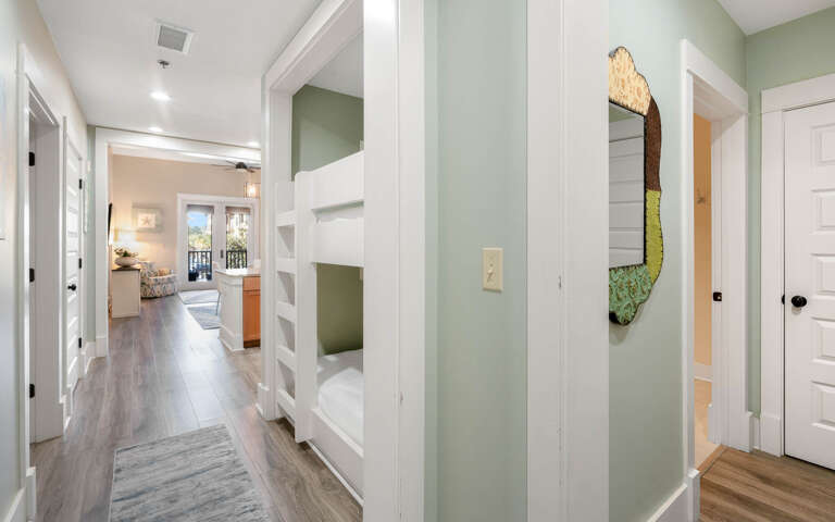 Step into your stylish hallway where thoughtful design meets comfortâbuilt-in bunks create cozy sleeping nooks while warm wood floors guide you through this welcoming space.