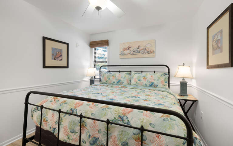 Drift off to sleep on your cozy bed surrounded by beautiful ocean-themed artwork and gentle coastal colors that create a serene retreat.