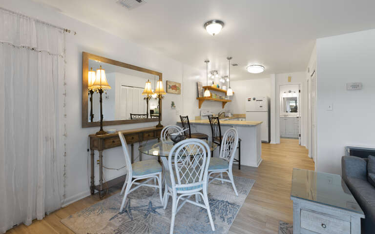 Step into your bright dining space where coastal charm meets comfortâperfect for sharing meals around the glass table.
