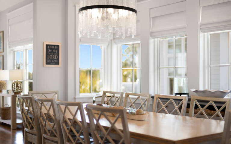 Gather around this elegant dining table where your group can share memorable meals beneath the sparkling chandelier.