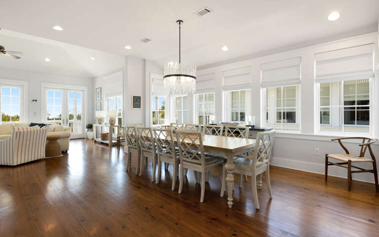 Gather around this elegant dining table where warm hardwood floors and crystal chandelier create perfect moments for your memorable meals together.