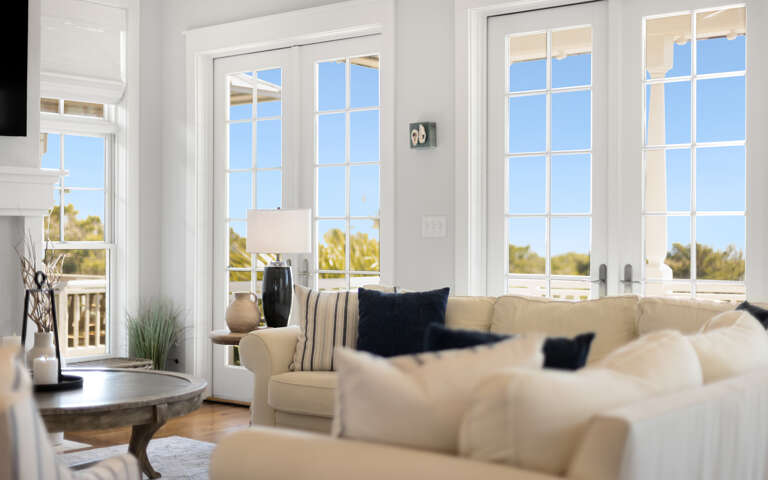 Sink into plush sofas while natural light floods your bright living space through elegant French doors opening to your private balcony.