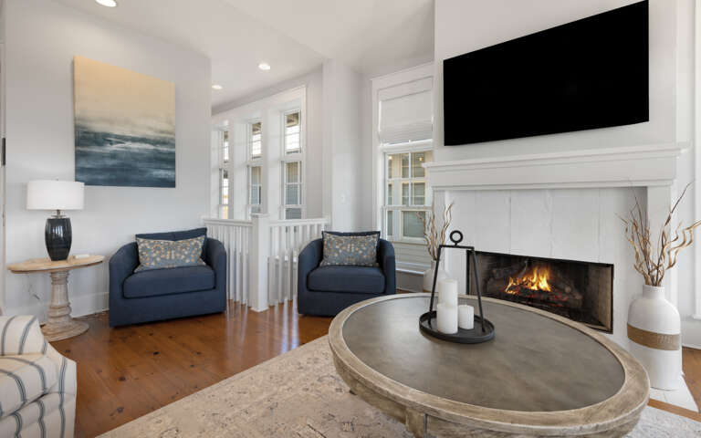 Unwind in your elegant living space with a cozy fireplace, plush seating, and entertainment center for perfect evening relaxation.