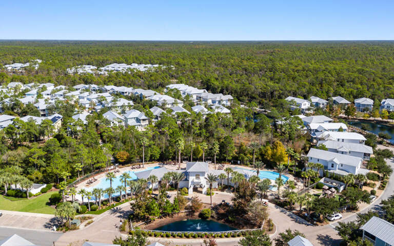 Aerial View Of Clustered Buildings Surrounding Curvy Pools Amidst Lush Greenery