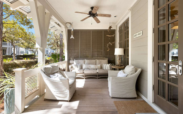 Your private covered porch invites relaxation with plush seating, ceiling fans, and peaceful neighborhood views.