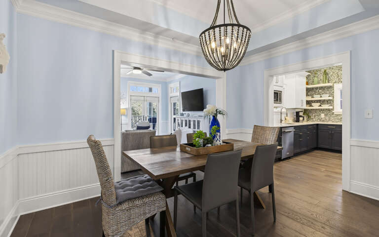 Gather around your elegant dining table beneath a stunning chandelier, with gleaming hardwood floors and an open kitchen perfect for entertaining.
