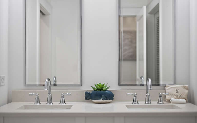 You'll love this elegant dual-sink vanity with soft lighting and thoughtful touches like fresh greenery to start your mornings right.