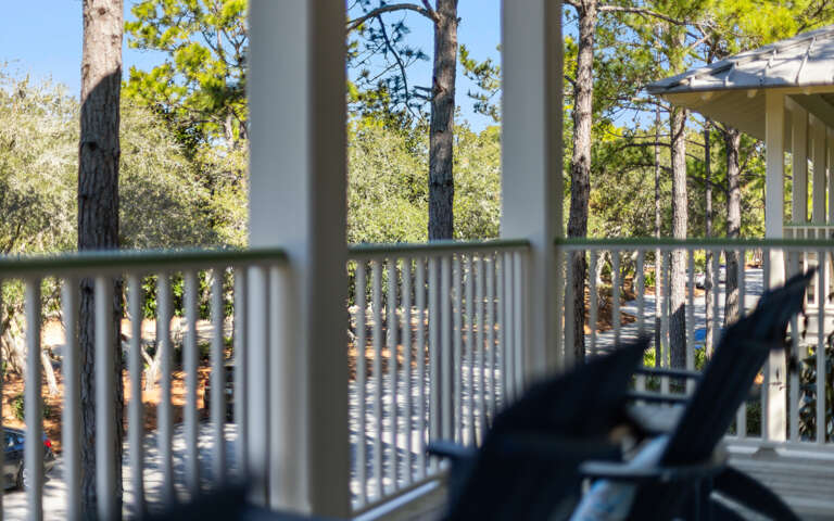 Relax on your private balcony surrounded by towering pine trees, where dappled sunlight creates the perfect retreat for your morning coffee.
