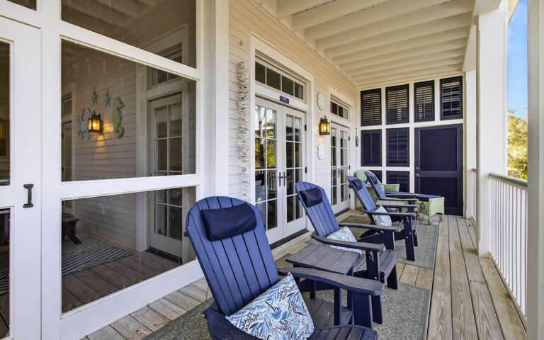 Unwind on your private covered porch with comfortable navy Adirondack chairs, perfect for morning coffee or evening relaxation.