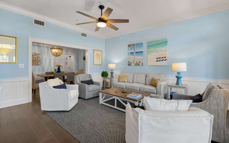 Unwind in your spacious coastal living room with plush seating and calming beach artwork that creates the perfect atmosphere for relaxation.