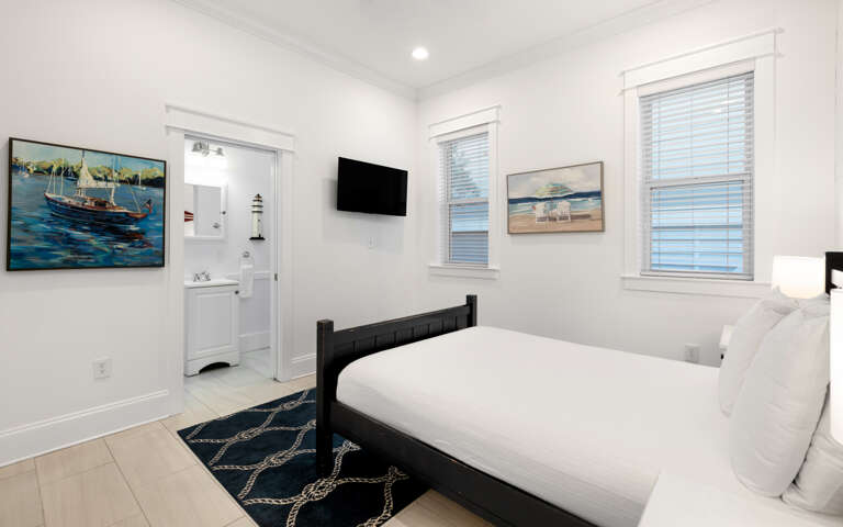 Drift off to sleep in your coastal-themed bedroom, where nautical artwork and crisp white linens create a serene retreat with modern conveniences.