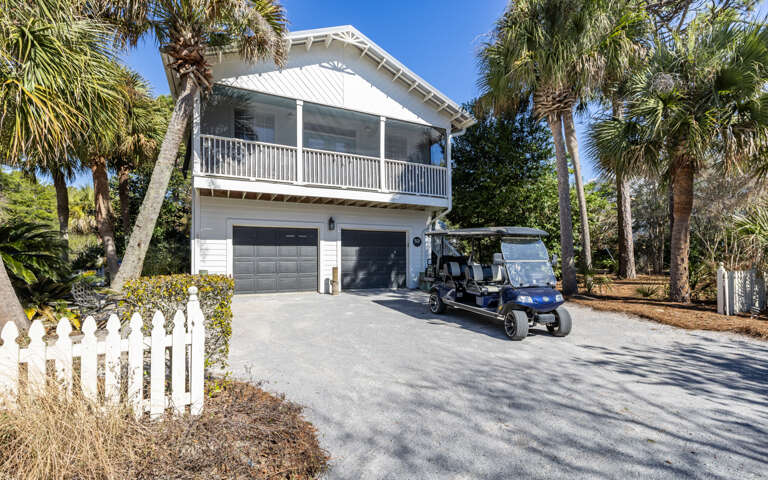Charming coastal home with tropical landscaping and convenient golf cart parking for easy island exploration.