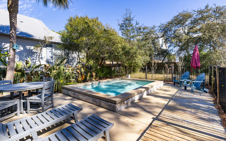 Dive into your private heated pool surrounded by tropical palms and mature trees, with comfortable loungers waiting for your afternoon relaxation.