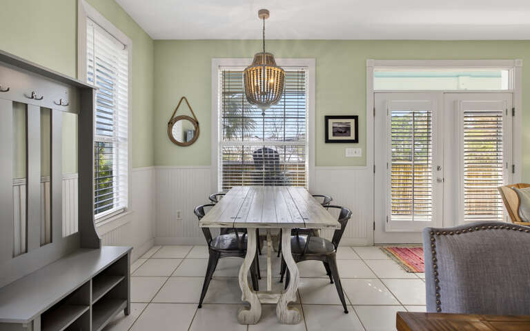 Gather around your elegant dining table under the warm chandelier glow, perfect for memorable meals and conversations.