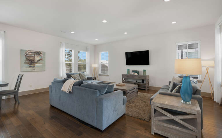 Sink into plush blue sofas and unwind in your bright, modern living space with entertainment ready.