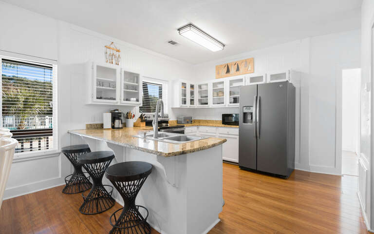 Your bright, fully-equipped kitchen features granite countertops, stainless steel appliances, and a breakfast bar perfect for morning coffee.