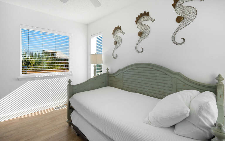 Your coastal bedroom features whimsical seahorse art and a charming sage-green headboard, with crisp linens awaiting your restful stay.