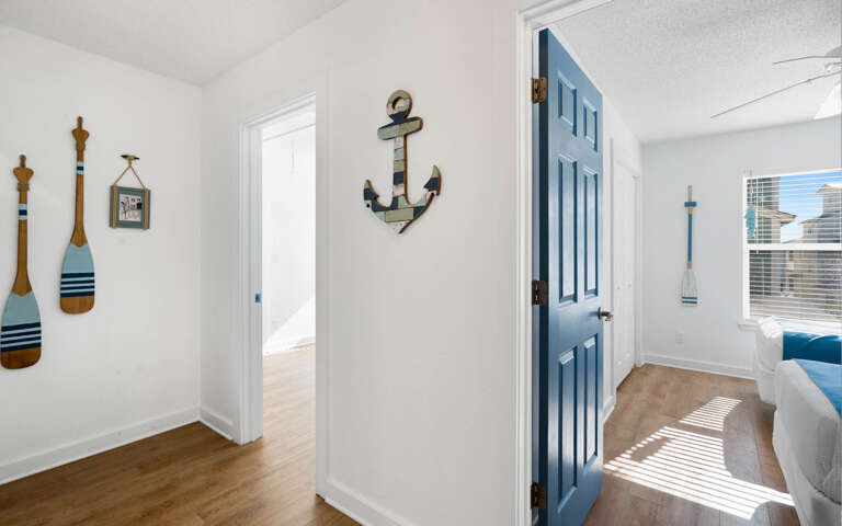 Step into your coastal haven where nautical charm meets modern comfortâsun-dappled floors and cheerful blue accents create the perfect seaside escape.