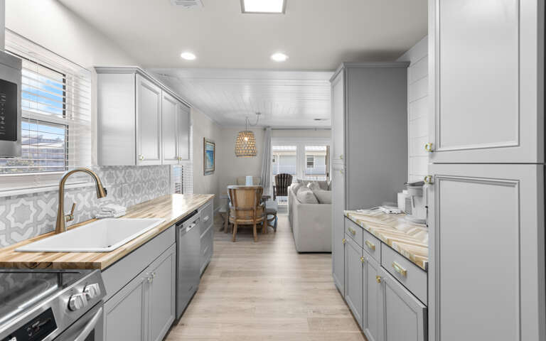 Your fully equipped galley kitchen flows seamlessly into the living space, featuring brass fixtures and elegant details.