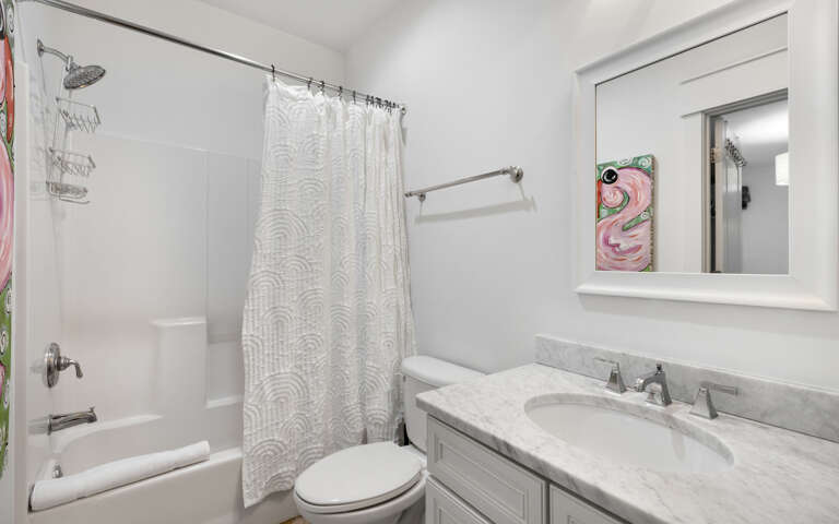 Step into your pristine private bathroom with elegant marble counters, fresh towels, and a relaxing tub-shower combo.