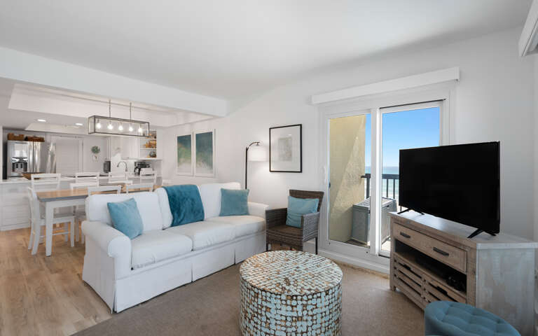 Your bright, coastal living room blends comfort with modern style, featuring gulf-inspired blues and a private balcony for morning coffee moments.