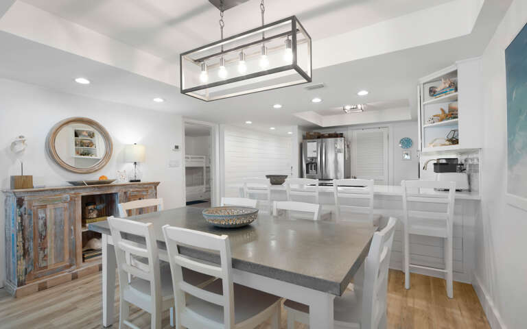 Gather with loved ones in your open-concept kitchen and dining area, where bright white finishes and elegant lighting create the perfect backdrop for memorable meals.