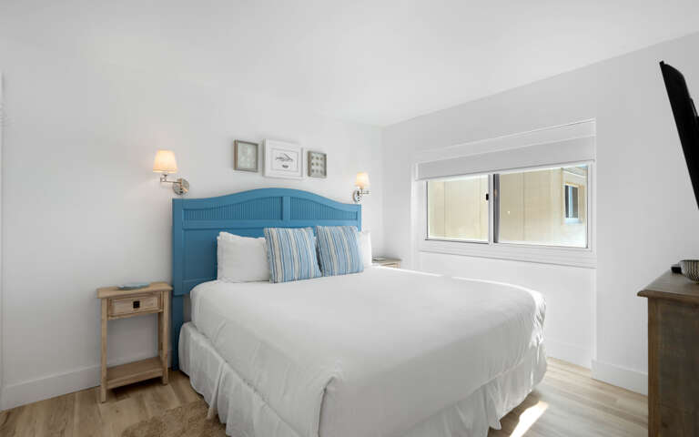 Sink into crisp white linens and let the coastal blue headboard transport you to seaside dreams in your peaceful retreat.